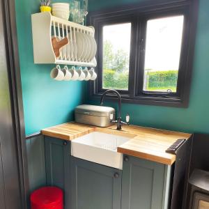 a kitchen with a sink and a window at Old King William Shepherd Huts and Private Hot Tubs in North Norfolk in Hunworth