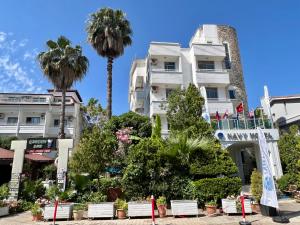 a white building with palm trees in front of it at Navy Hotel in Marmaris