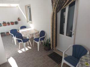 a room with a table and chairs and a door at Apartments Slavica in Bol
