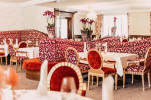 a restaurant with tables and couches and tables and chairs at Hotel Schloss Seefels in P&ouml;rtschach am W&ouml;rthersee