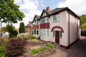 uma casa branca com uma porta vermelha numa rua em Comfortable rooms em Birmingham