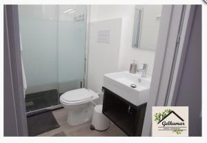 a bathroom with a toilet and a sink and a shower at Gelkamar Apartment in Santa Flavia +6 photos