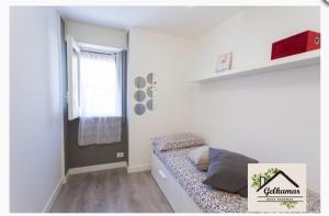 a small white room with a bed and a window at Gelkamar Apartment in Santa Flavia