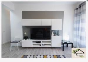 a white living room with a tv and a couch at Gelkamar Apartment in Santa Flavia