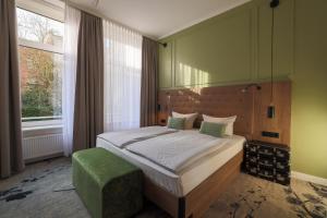 a bedroom with a bed and a green wall at LIHO - einfach Lübeck in Lübeck