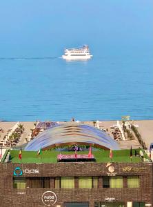 um grande edifício na praia com um barco na água em Aqua Vista NUBA 5 - Vedere Top la Mare - Summerland em Mamaia