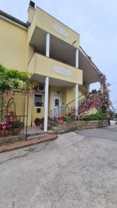 a yellow building with flowers in front of it at apartment IVA in Supetarska Draga
