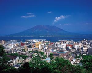 uitzicht op een stad met een berg op de achtergrond bij Hotel Fukiageso in Kagoshima