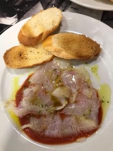a plate of food with meat and bread on it at Hostal Vila del Mar in Lloret de Mar
