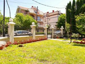 a fence in front of a house with a yard at Vila Nikola in Soko Banja