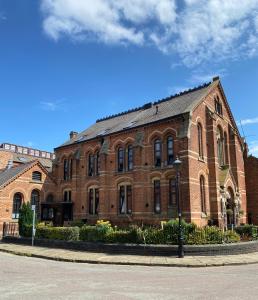 a large brick building on the side of a street at Luxury Chapel Apartment within City Walls in Chester