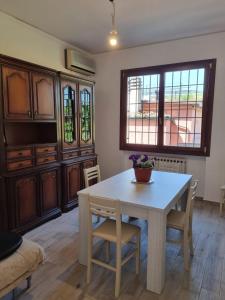 uma sala de jantar com uma mesa e cadeiras e uma janela em Appartamento Via Loreto em Pistoia