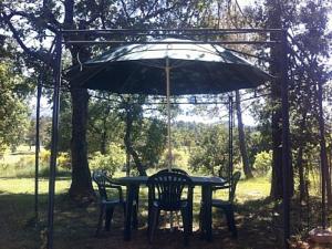 a table with two chairs and an umbrella at Putt Tee Country in Nans-les-Pins