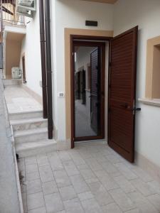 una porta in legno in un edificio con pavimento piastrellato di Appartamenti Petali Di Rosa a Custonaci