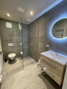 a bathroom with a sink and a toilet and a mirror at Haus Hager in Sankt Johann in Tirol +38 photos