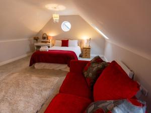 een slaapkamer op zolder met een bed en een bank bij Pass the Keys Superb space in the idyllic village of Loppington in Shrewsbury