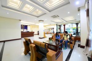 dwoje ludzi siedzących na kanapie w holu w obiekcie Vientiane Luxury Hotel w mieście Wientian