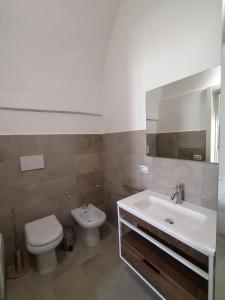 a bathroom with a sink and a toilet and a mirror at Poggio Fiorito in Porto Cesareo