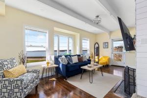 uma sala de estar com um sofá azul e janelas em Spacious Coastal Tiverton Waterfront Getaway cottage em Tiverton