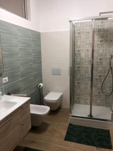 uma casa de banho com um chuveiro, um WC e um lavatório. em Case Pagano Mare em Taormina