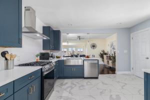 una cocina con armarios azules y fregadero en Spacious Coastal Tiverton Waterfront Getaway cottage, en Tiverton