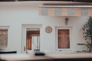 een witte muur met drie ramen in een kamer bij Frangipani Penthouse in New Delhi