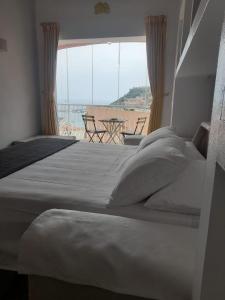 La finestra sul porto في بورتو إركولي: غرفة نوم بسريرين واطلالة على شرفة