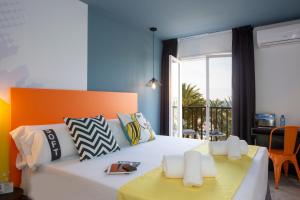 a bedroom with a white bed with an orange and blue wall at Casual Pop Art Benidorm in Benidorm