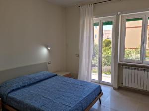 ein Schlafzimmer mit einem Bett und einem großen Fenster in der Unterkunft Casa Sofia in Gaeta