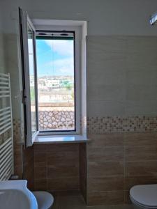 a bathroom with a window and a sink and a toilet at Casa Sofia in Gaeta