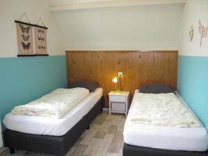 um quarto com duas camas num quarto com em Ferienhaus HET GANZELAND OOST100 em Oostmahorn