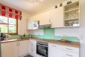 a kitchen with white cabinets and green counter tops at Magdalena in Bad Hindelang