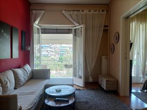 un soggiorno con divano e una grande finestra di Charming Retreat ad Atene