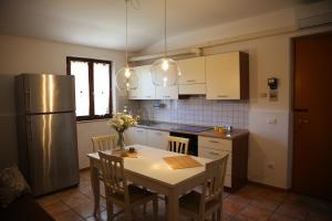 een keuken met een tafel met stoelen en een koelkast bij Appartamenti il PALAZZACCIO in Acqualagna