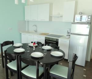 uma cozinha com uma mesa e cadeiras pretas e um frigorífico em Apartman Crikvenica 30103 - Zdravko em Crikvenica