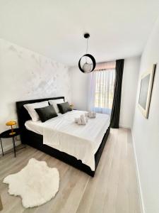 a bedroom with a large bed with white sheets and a window at Apartmani CUBE A in Medulin
