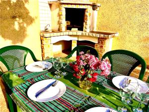 a table with plates and flowers and a fireplace at Holiday Home Viko in Sutomore