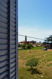 widok na budynek i pole z drzewem w obiekcie Apartman Volare w mieście Vodnjan