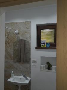 a bathroom with a sink and a mirror and a window at Casa Chriss in Eforie Sud