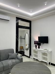 ein Wohnzimmer mit einem Sofa und einem Spiegel in der Unterkunft Ferdinando's Home in Neapel