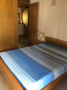 a bedroom with a bed with a blue comforter at Casa dell'Olivo in Castione Andevenno +10 photos