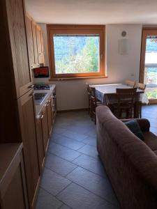 uma cozinha com uma mesa e um sofá e uma cozinha com uma janela em Casa dell'Olivo em Castione Andevenno