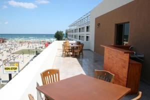 a balcony with tables and chairs and a view of the beach at Hotel Mihaela in Mamaia