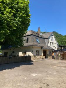 a large white house with a tree in front of it at Bergs Bahnhof in Ralingen