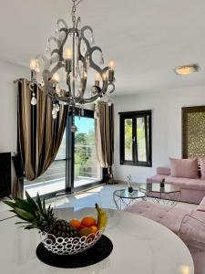 a dining room with a chandelier and a bowl of fruit at Golden King Villas in Vassilias