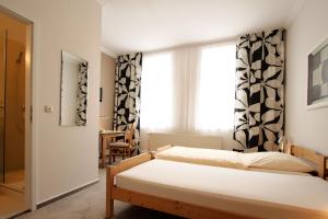 1 Schlafzimmer mit 2 Betten und einem Fenster in der Unterkunft Hotel Galerie in Seelze