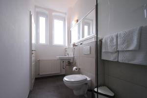 a white bathroom with a toilet and a sink at Hotel Galerie in Seelze