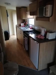 une cuisine avec une cuisinière et un comptoir dans l'établissement YY20 Martello Beach Holiday Park, à Clacton-on-Sea 6 autres photos