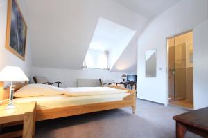 ein Schlafzimmer mit einem großen Holzbett in einem Zimmer in der Unterkunft Hotel Galerie in Seelze
