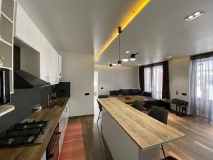 cocina y sala de estar con barra y mesa en Riverside en Slavske